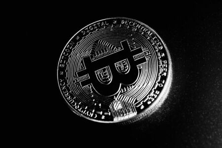 Bitcoin on black background. Macro photo. Cryptocurrency price drop.の写真素材