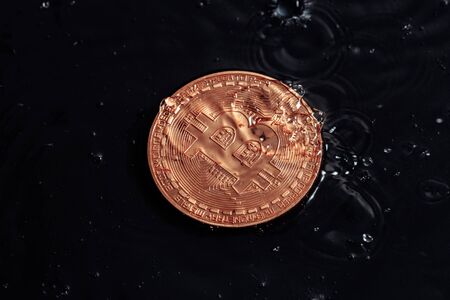 Cryptocurrency coins on a dark background. Macro photo. Rain drops on coins.
