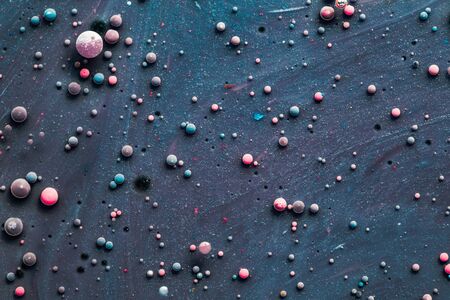 Color drops floating in oil and water over a colorful underground with oil painting effect.の写真素材