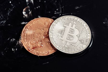Bitcoin on black background. Bitcoin laundering with water.の写真素材