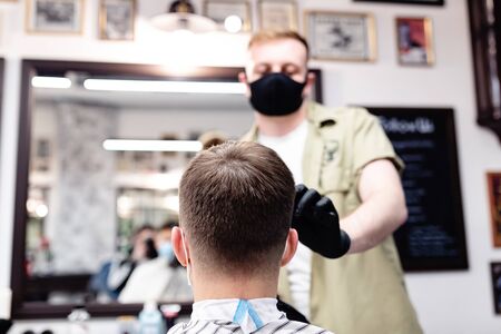 Barber and client in mask against virus. Haircut in quarantine.の写真素材