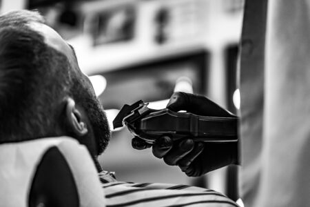 Mens haircut in a barbershop. Client and barber in anti-virus masks.の写真素材