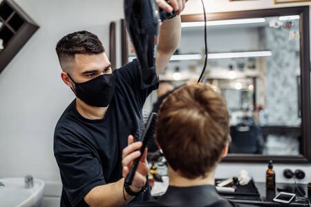 Styling mens hair. Barber make a stylish hairstyle.の写真素材