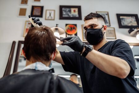 Barber makes a haircut and hair styling in a barbershop, beauty salon.の写真素材