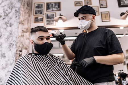 Haircut in quarantine. Haircut in masks from the virus. Hair and health care.の写真素材