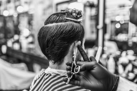 Barber makes a haircut and hair styling in a barbershop, beauty salon.の写真素材