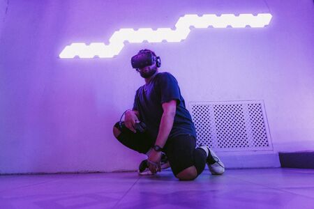 The guy is sitting in virtual reality. Neon retro style. The photo shows the effect of grain, noise.の写真素材