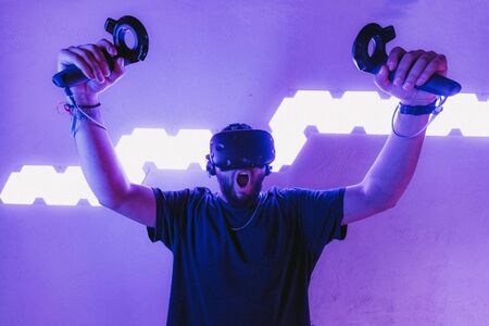 The guy is sitting in virtual reality. Neon retro style. The photo shows the effect of grain, noise.の写真素材