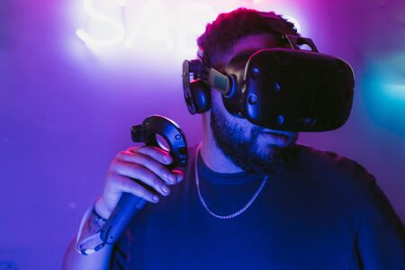 The guy is playing VR games. Neon blue light.の写真素材