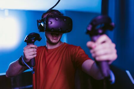 VR E-Sports. The guy is playing an online shooter in the game neon room.の写真素材
