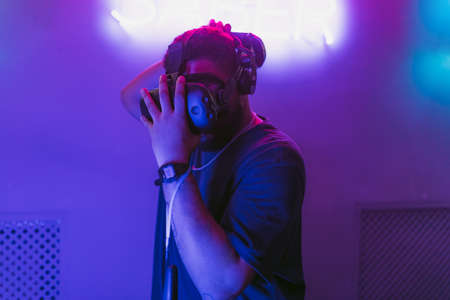 Man in a cyber helmet. New VR games in the neon room.の写真素材