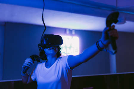 The girl gets new impressions of virtual reality. Neon gaming room.の写真素材