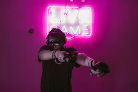 Extreme in virtual reality. Man playing games through VR helmet.の写真素材
