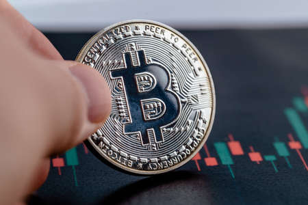 Close-up photo of crypto coin in hands. Bitcoin economy.の写真素材