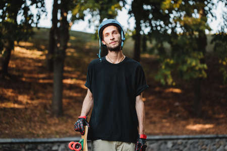 Portrait of a guy in a blue helmet with a longboard.の写真素材