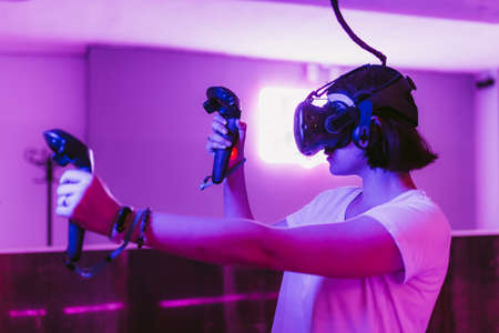 Girl in a purple VR room playing games.の写真素材