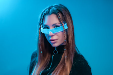 Cool cyberpunk portrait of a young woman. Woman in futuristic neon glasses.の写真素材