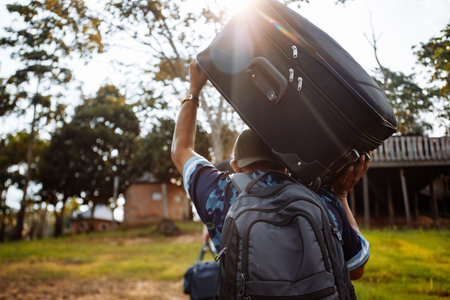 The man carries a suitcase on his shoulder.