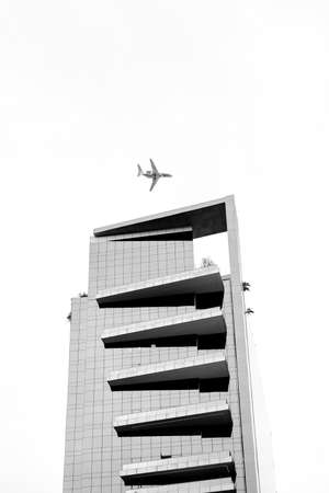 The plane flies over the house.の写真素材