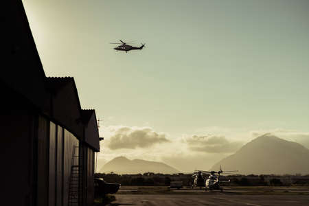 Hangar with helicopters at sunset.の写真素材