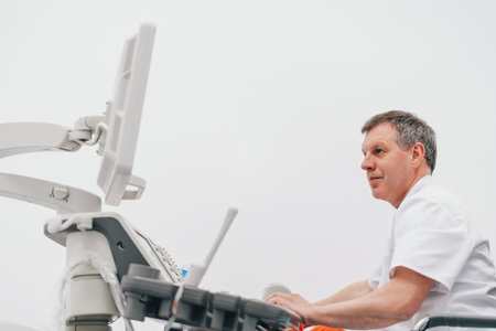 The doctor gives the woman an ultrasound of the thyroid gland.の写真素材