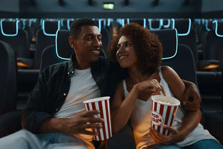 Couple watching comedy in 3d glasses with popcorn.の写真素材