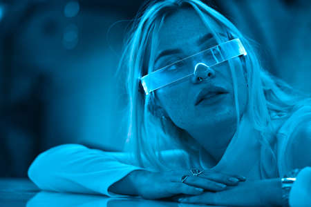 Young woman in neon glasses. Futuristic blonde.