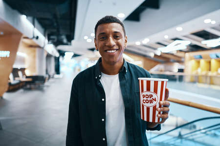 The man came to the meaning of the movie in the cinema with popcorn.の写真素材