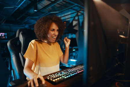 A young woman won a game. Winning the tournament. Neon playroom.の写真素材