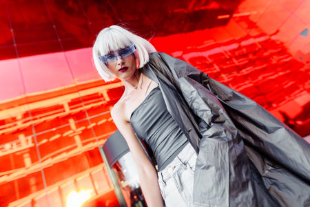 Woman in stylish glasses on a red background.の写真素材