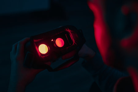 A man connects to VR. Neon light in the gaming room.