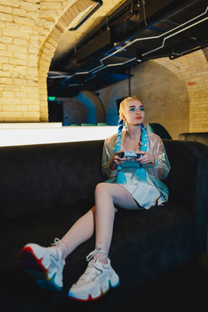Blonde gamer plays console.