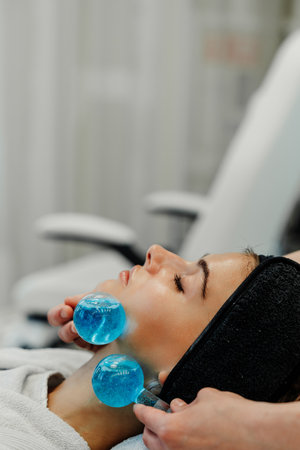 The master gives the client a relaxing facial massage using cold cryo spheres.の写真素材