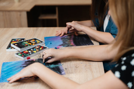 Art workshop with participants creating pastel landscapes indoorsの写真素材