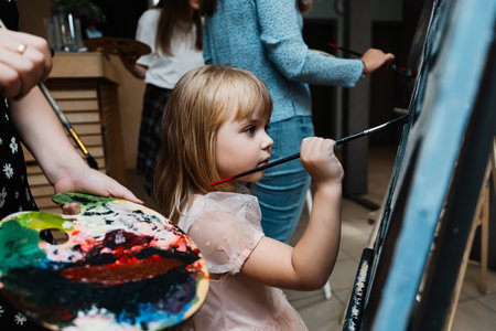Girl painting on a canvas during a creative art class indoors