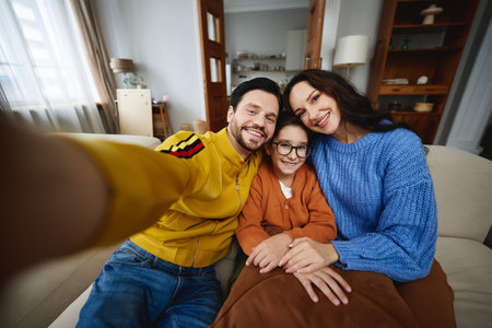 A cheerful family sharing a cozy moment together in their living roomの写真素材