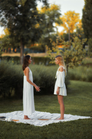 Two women engage in a mindful conversation in a serene outdoor park setting