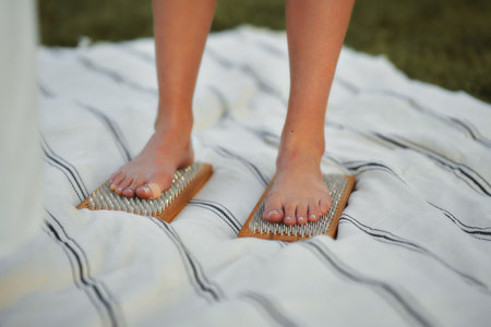Barefoot participant engages in a grounding activity on a blanket outdoorsの写真素材