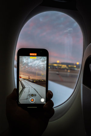 Capturing a sunset view from an airplane window with a smartphoneの写真素材