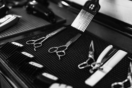 Sharp scissors and tools set on black textured surface in barbershopの写真素材