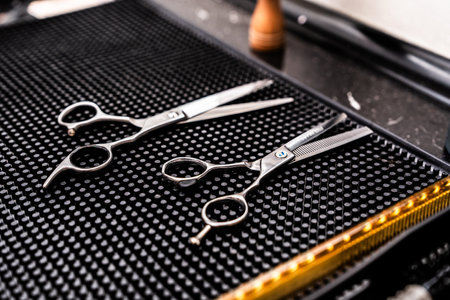 High-quality hairdressing scissors placed on a textured dark surfaceの写真素材