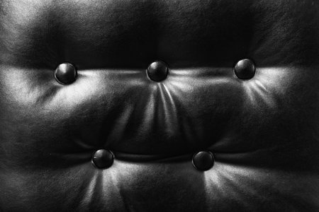 Textured black leather upholstery with buttoned craftsmanship detailsの写真素材