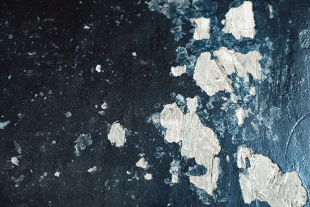 Texture of peeling paint on a dark surface with a unique patternの写真素材