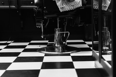 Black and white barber shop interior with checkered flooring and styling chairの写真素材