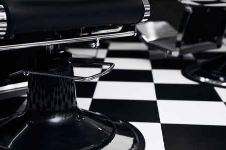 Stylish black-and-white barber shop with checkered floor and chairsの写真素材