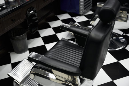 Stylish black salon chair in a modern barbershop with checkered floor designの写真素材