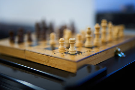 Chess game in progress on a wooden board with classic pieces and strategic moves