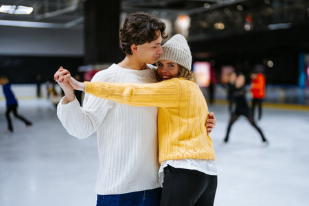 Couple enjoying ice skating together at a rink during winterの写真素材
