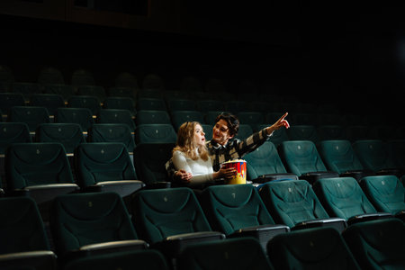 Couple enjoying a movie night in a nearly empty theaterの写真素材