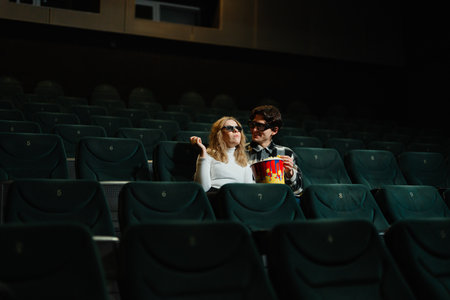 Couple enjoying a movie night in a nearly empty theaterの写真素材
